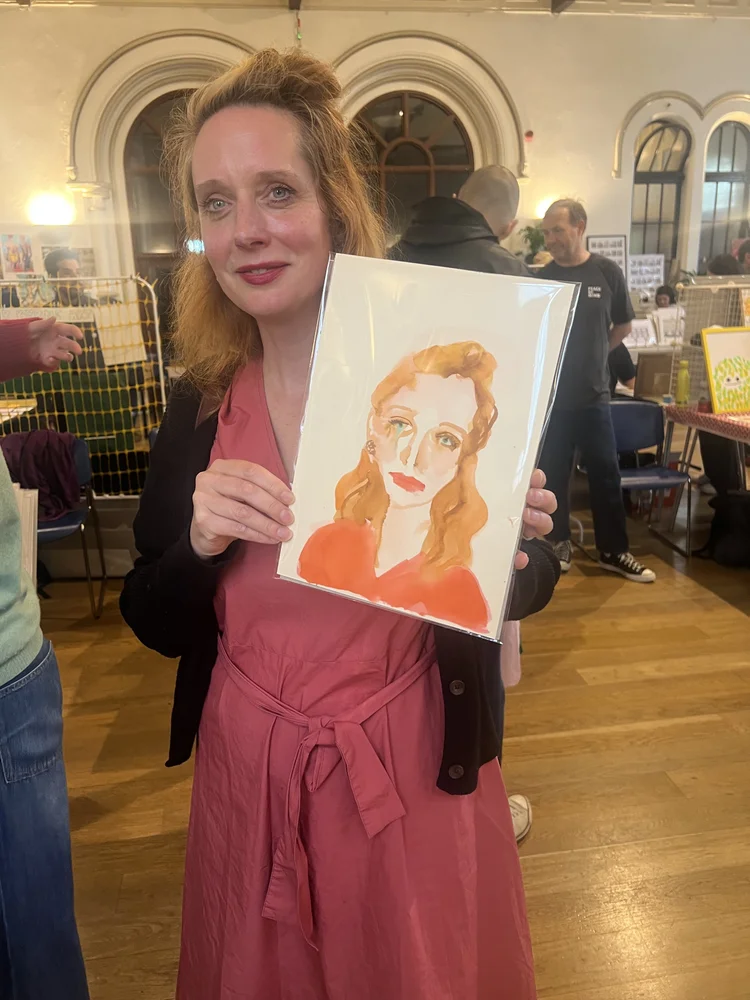 People holding watercolour portraits at a live event illustration by Tracey Smith.
